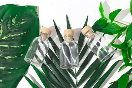 Three glass bottles with cork stoppers for perfumes with exotic plants. Mockup.の写真素材