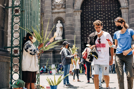 Artisans sell palm figures during the Palm Sunday celebration outside the Puebla Cathedralのeditorial素材