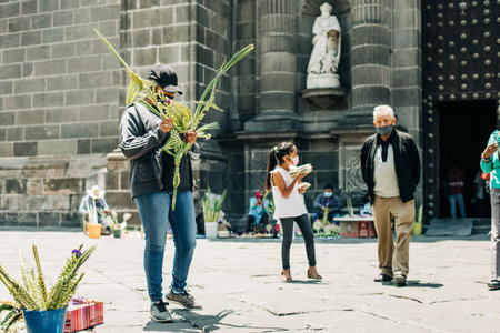 Artisans sell palm figures during the Palm Sunday celebration outside the Puebla Cathedralのeditorial素材