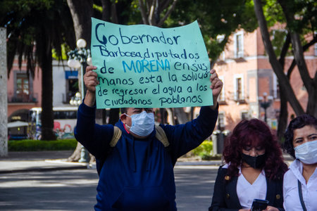 Citizen groups demonstrate against the increase in drinking water rates in Puebla in front of the State Congressのeditorial素材