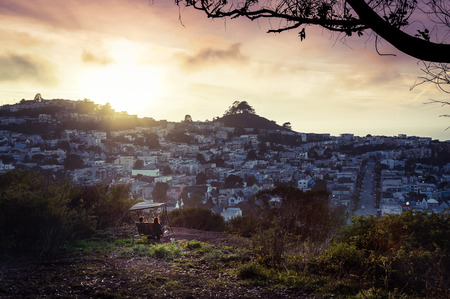 A couple enjoying a beautiful sunset at their secret spot in San Francisco, Californiaの写真素材