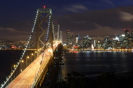 San Francisco Bay Bridge and skyline at night with city lights