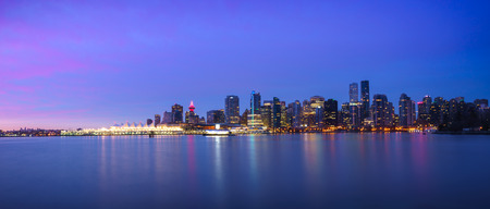 Panoramic view of Vancouver Skyline at Sunrise with City Lights as seen from Stanley Park, Vancouver, British Columbia, Canadaの写真素材