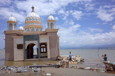 PALU, INDONESIA - OCTOBER 11th, 2018: A partially submerged mosque that has been knocked off its foundations by an earthquake and a tsunami, on October 11th, 2018 in Palu, Indonesia. A tsunami triggered by a magnitude 7.5 earthquake slammed into Indonesiaのeditorial素材