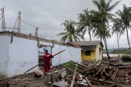 Tsunami victims collects items from a damaged house in Carita district, Banten province, Indonesia on December 28, 2018のeditorial素材