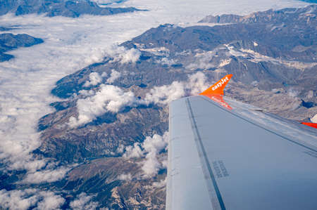 Geneva Switzerland -17.09.2021: View from the plane. EasyJet flight wing, mountains and sea of clouds. Travel.のeditorial素材
