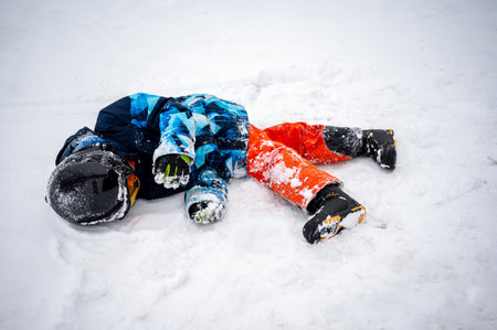 Person with snowboard on the snow. One Asian child is lying on the ground. Winter sport.の写真素材