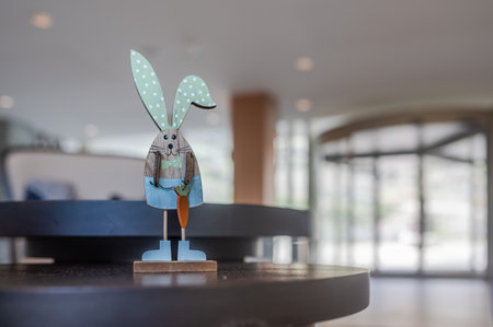 Easter rabbit with carrot on table. One blue Easter wooden bunny. Holidays backgrounds.の写真素材