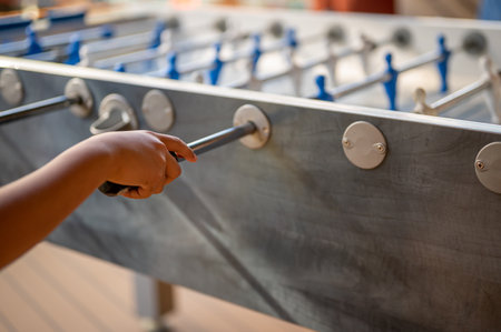 Hand playing foosball. People enjoying table soccer game.の写真素材