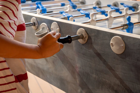 Hand playing foosball. People enjoying table soccer game.