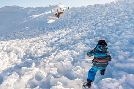 One Child Walking and Playing in Deep Snow on a Sunny Winter Day. Rochers-de-Naye, Vaud,...