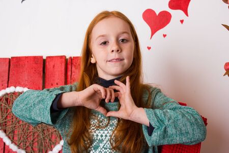 Form of heart shaped by the hands of a beautiful cute young girlのeditorial素材