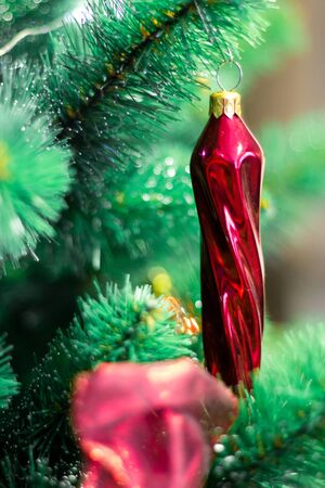 Macro image of red toy ball hanging on christmas tree branchの写真素材