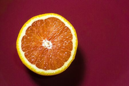 Top view of piece of grapefruit on red surfaceの写真素材