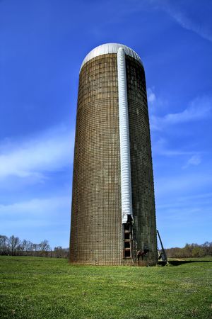 Close up of a grain silo sitting in the middle of a big field on a livestock plantation.の写真素材
