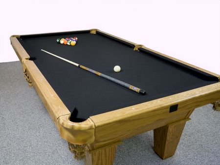 Luxury black table top pool table with racked billiards and stick laying on top.