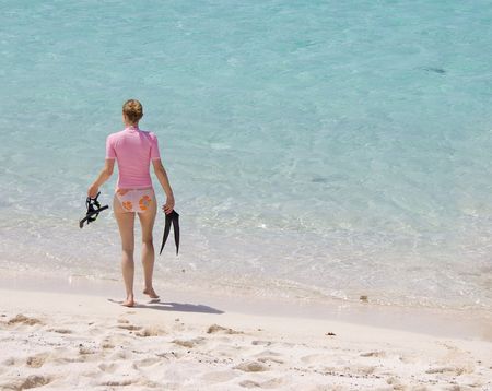 Young woman walking into tropical water to go snorkeling.の写真素材