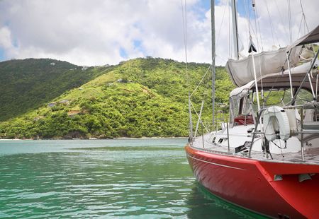 Beautiful large and luxurious sailboat anchored next to a tropical island.の写真素材