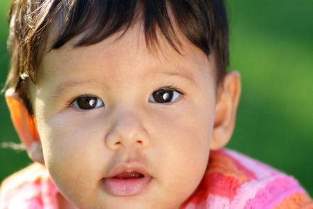 Closeup of a very cute baby or toddler in bright pink clothings.