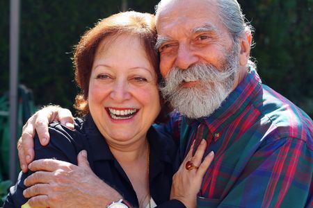 Affectionate old couple with the husband holding on lovingly to the wife. Concept: Elderly love.