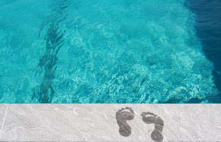 Foot steps by the swimming pool. Concept: Summer vacation by the beachの写真素材