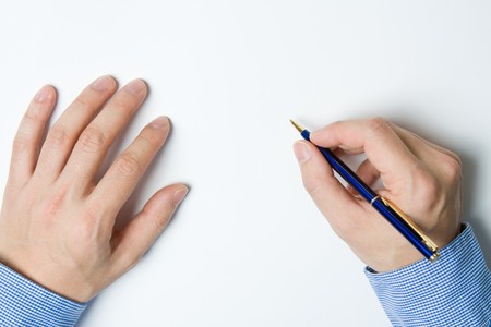 Person writing a message on a piece of paper or note