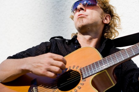 Rock star with acoustic guitar performing live in the summer
