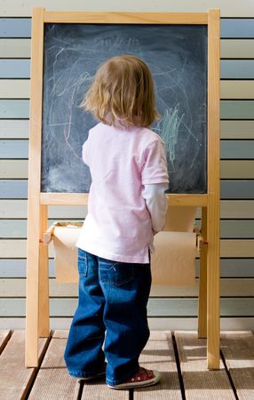 Cute young caucasian boy writing on a blackboard in school or kindergartenの写真素材