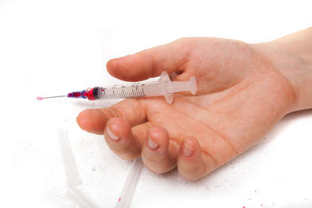 Syringe in a palm of the addict after overdoseの写真素材