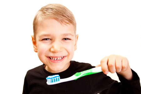 The boy brushes teeth a brush on a white backgroundの写真素材