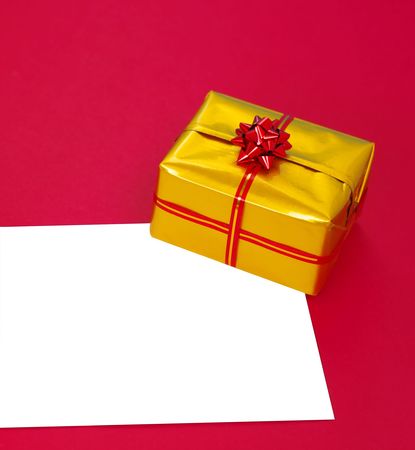 form and  present box in gold wrap on red backgroundの写真素材