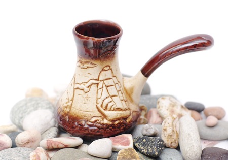 ceramic coffee cezve on multi-coloured pebblesの写真素材