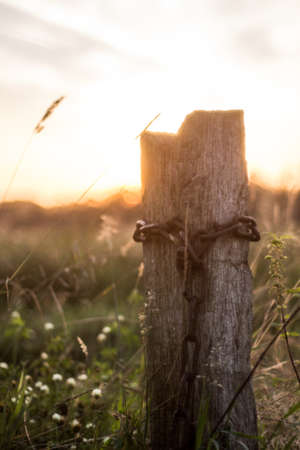 a rusty chain on a fence postの写真素材