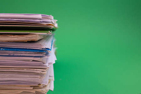 stack of paper against a green backgroundの写真素材