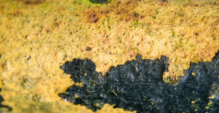 rusty metal part with rests of black paint