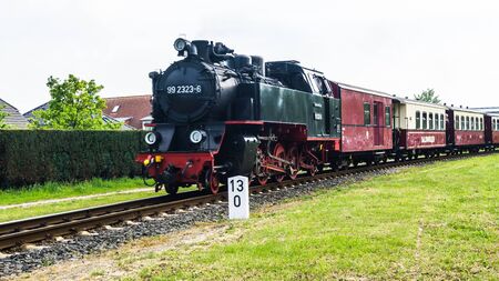 Kuehlungsborn, Germany - May 17, 2019 - steam locomotive Molli pulling coaches through Kuehlungsborn