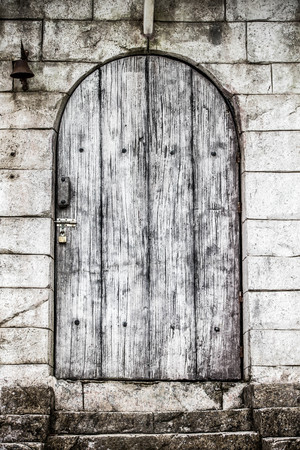 Old wooden door vintage,There is a bell on the wall.の写真素材