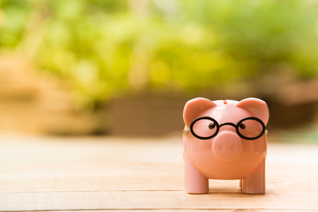 Piggy bank pink color on the wooden table.の写真素材
