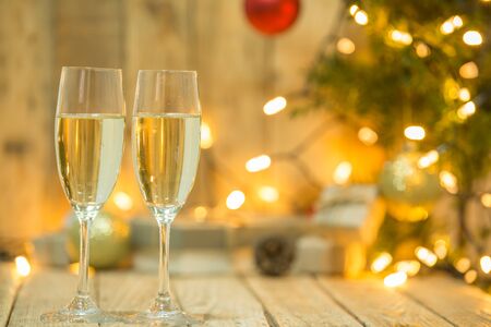Wine glasses in front of a Christmas treeの写真素材