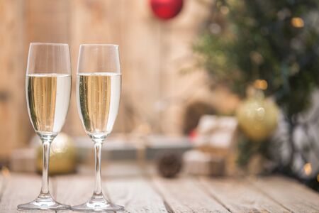Wine glasses in front of a Christmas treeの写真素材
