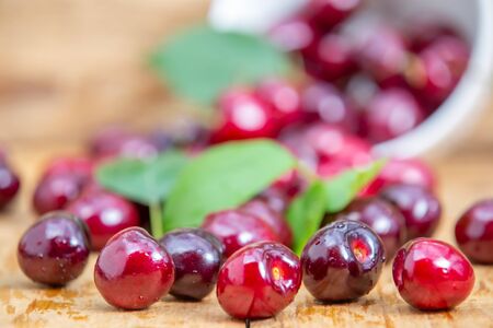 Fresh cherries in the white bowl on wood tableの写真素材