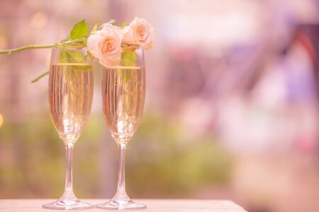 Rose flower on glass wine with blur bokeh backgroundの写真素材
