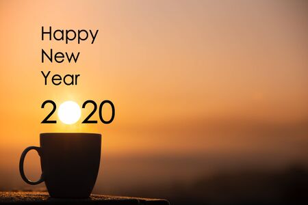 Silhouette coffee cup with happy new year 2020 text on a sunrise backgroundの写真素材