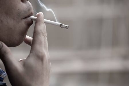 man smoking a cigarette. Cigarette smoke spread.の写真素材