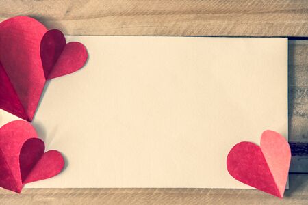 Valentine's day red hearts with blank notepad on brown wooden tableの写真素材