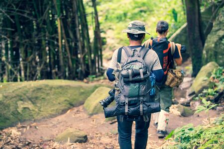 Group friend walking in the wild with a heavy backpack. Travel Lifestyle wanderlust adventure concept summer vacations in the wildの写真素材