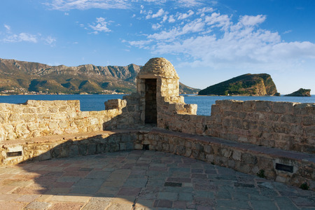 Ancient fortification walls of Old Town of Budva with Sveti Nikola island view. Montenegro, winterの写真素材