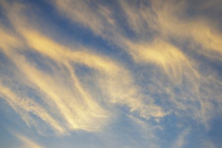 Blue sky with golden clouds at sunsetの写真素材