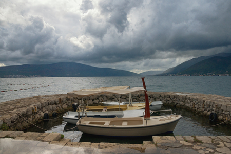 Boats in a small harbor before the storm. Bay of Kotor near Tivat city, Montenegroの写真素材