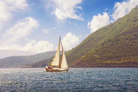 Sailboat sails  near shore of Bay of Kotor (Adriatic Sea) on a beautiful sunny day. Montenegro. Travel conceptの写真素材